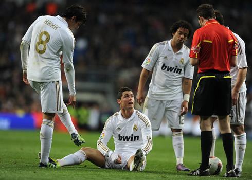 Cristiano Ronaldo seated on the ground and looking at the referee, while Kaká, Marcelo and Xabi Alonso also have a chat with the whistle man
