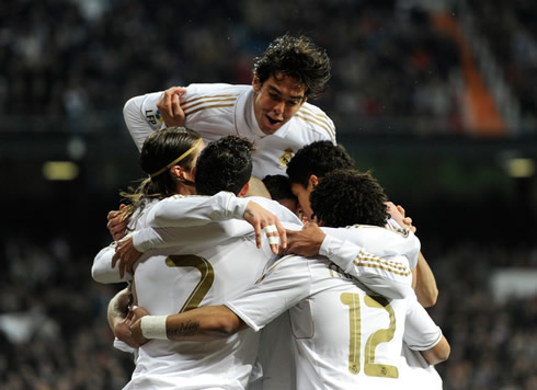 Cristiano Ronaldo in a Real Madrid group hug, with Kaká jumping over everyone in 2012