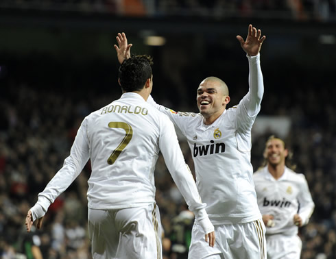 Cristiano Ronaldo preparing to hug Pepe, while Sergio Ramos approaches them in a Real Madrid goal celebrations in 2012