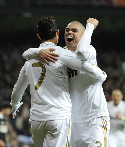 Cristiano Ronaldo hugged to Pepe, while the defender smiles with his mouth open, in a game for La Liga in 2012