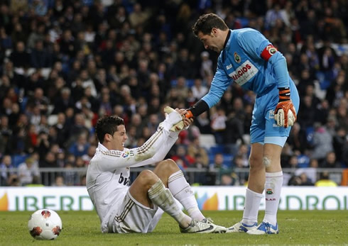 Cristiano Ronaldo gets helped by Racing Santander goalkeeper, so he may to get up from the ground in a Real Madrid match in 2012