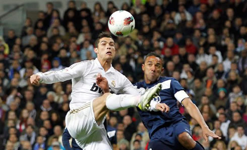 Cristiano Ronaldo stretching his right leg to reach the ball before a defender