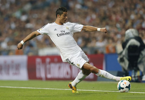 Cristiano Ronaldo stretching to control the ball before it crosses the sideline, in Real Madrid 2013-2014