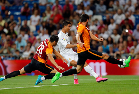 Cristiano Ronaldo shooting with his left foot, while marked by two defenders