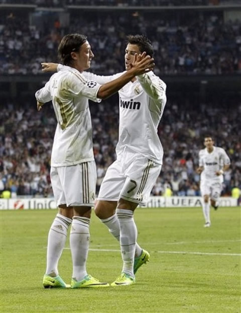 Cristiano Ronaldo touching hands with Mesut Ozil, in a Real Madrid match for the UEFA Champions League, in 2011/2012