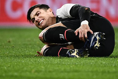 Cristiano Ronaldo holding his ankle after suffering a tackle