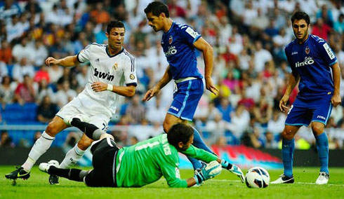 Diego Alves making a good stop, as Cristiano Ronaldo looks to the ball near him, in 2012-2013