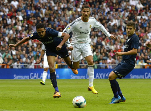 Cristiano Ronaldo running past two defenders in Real Madrid vs Malaga for the Spanish League 2013-14