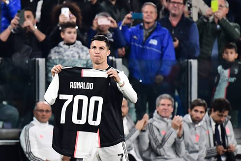 Cristiano Ronaldo holding his commemorative shirt for his 700 goals in his career