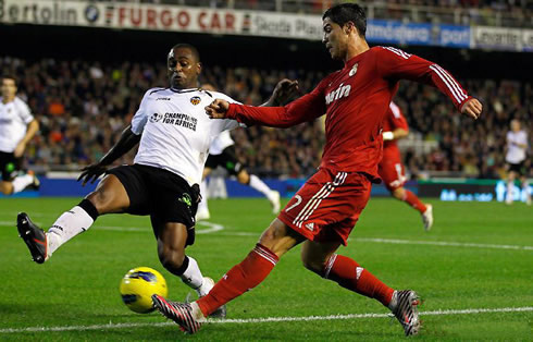 Cristiano Ronaldo crossing the ball with Miguel from Valencia attempting to block it