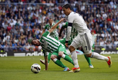 Cristiano Ronaldo gets past a Betis defender, during a game for Real Madrid at the Santiago Bernabéu, in La Liga 2013