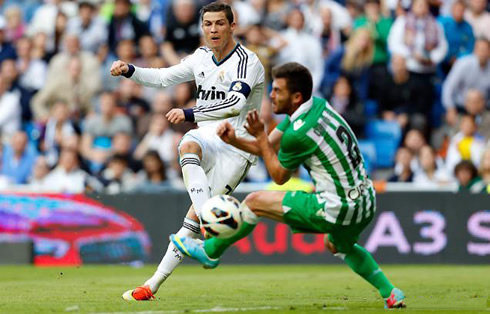 Cristiano Ronaldo tries to shoot the ball and make it go around a defender's body, in Real Madrid 3-1 Betis, for the Spanish League 2012-2013