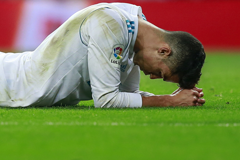 Cristiano Ronaldo lays on the ground and looks down