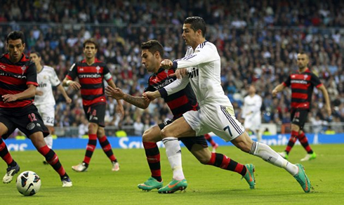 Cristiano Ronaldo trying to run away from a Celta de Vigo defender, in a game for Real Madrid in 2012-13