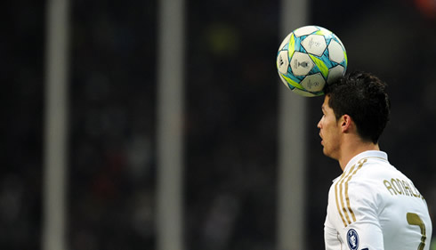 Cristiano Ronaldo holding the ball with the front of his head, in a Real Madrid match for the UEFA Champions League in 2011-2012