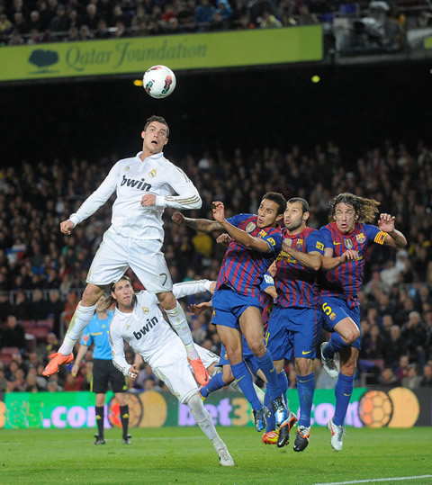 Cristiano Ronaldo jumping high and reaching a higher point than 3 Barcelona players