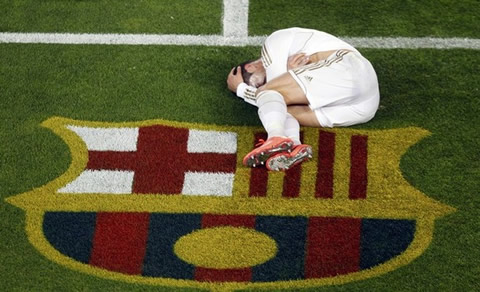 Cristiano Ronaldo injured in the Camp Nou, in the fetal position, just near Barcelona flag and symbol on the grass