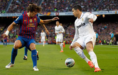 Cristiano Ronaldo preparing to dribble Carles Puyol, in Barcelona vs Real Madrid for La Liga in 2012