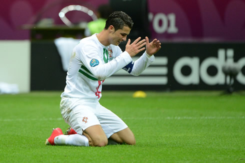 Cristiano Ronaldo gets down on his knees and reacts after another ball hits the post at the EURO 2012