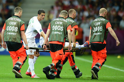 Cristiano Ronaldo checking up with Hélder Postiga and wishing him luck as he goes off the pitch injured and lied on a stretched bed, at the EURO 2012