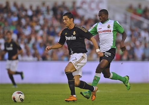 Cristiano Ronaldo running in front of a defender in Racing Santander vs Real Madrid, La Liga match in 2011-2012