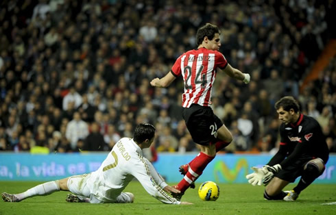 Cristiano Ronaldo falls down near an Athletic Bilbao defender and the goalkeeper