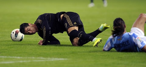 Cristiano Ronaldo gets tackled by De Michelis, in Malaga vs Real Madrid