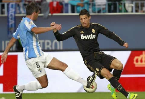 Cristiano Ronaldo about to dribble Toulalan from Malaga