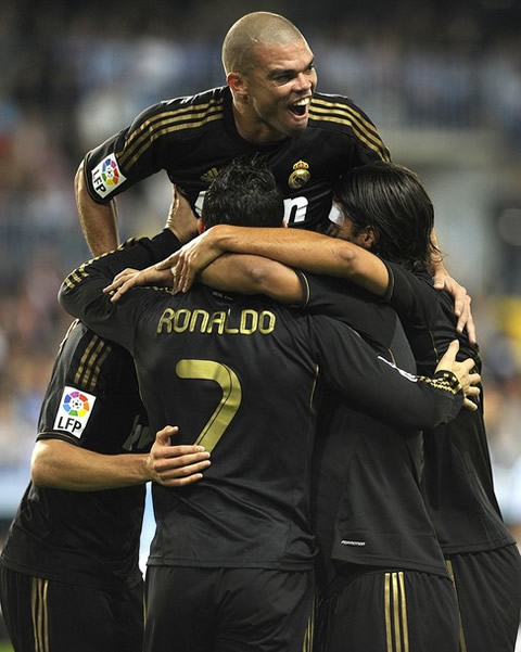 Cristiano Ronaldo celebrating a Real Madrid goal in a team hug
