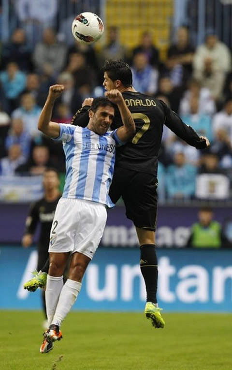 Cristiano Ronaldo jumps higher than a defender to head the ball