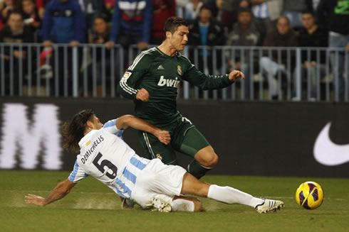 Cristiano Ronaldo trying to avoid a sliding tackle from Demichelis, in Malaga vs Real Madrid for the Spanish League, in 2012-2013