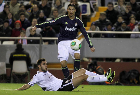 Cristiano Ronaldo jumping over a Valencia defender, in a match for Real Madrid in 2013