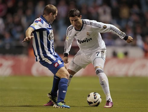 Cristiano Ronaldo trying to get past a Deportivo defender, in a match for Real Madrid in the Spanish League 2013