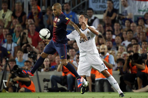 Daniel Alves jumping ahead of Cristiano Ronaldo, to receive a ball in the air, in Barcelona vs Real Madrid 2012/2013