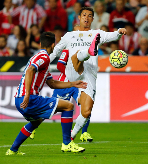 Cristiano Ronaldo stretching his right leg to touch the ball at the El Molinón stadium