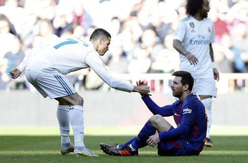 Cristiano Ronaldo stretching his hand to help Lionel Messi stand up in El Clasico
