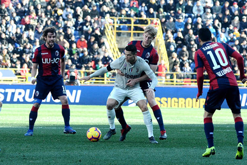 Cristiano Ronaldo held by a defender and surrounded by opponents in Bologna vs Juventus