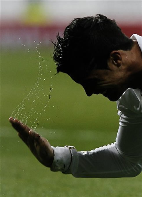 Cristiano Ronaldo tapping the pitch and making some water jump
