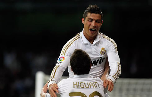 Cristiano Ronaldo jumping to Gonzalo Higuaín lap in a Real Madrid match for La Liga in 2012