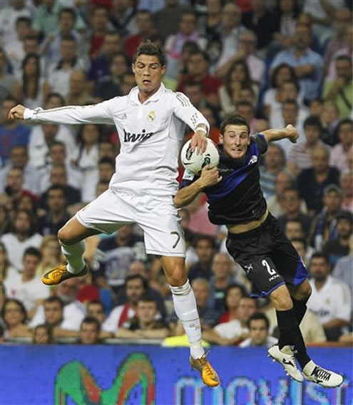 Cristiano Ronaldo jumps with an opponent from Rayo Vallecano in La Liga match from 2011-2012
