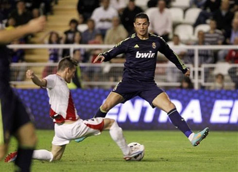 Cristiano Ronaldo jumping in the air with his two legs wide open, in a game for Real Madrid in 2012-2013