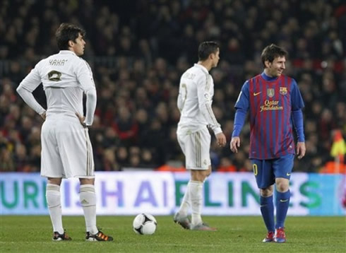 Cristiano Ronaldo and Kaká looking at something, while Lionel Messi passes by, with a big smile on his face