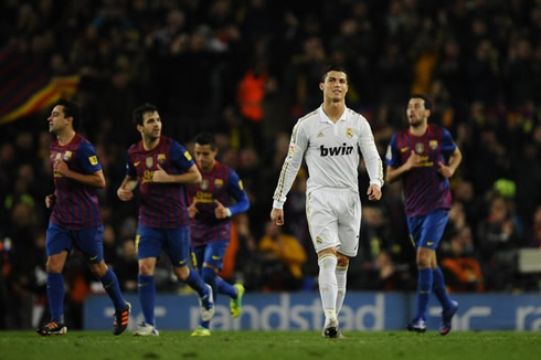 Cristiano Ronaldo walking away while Barcelona players return to the their side of the pitch after scoring a goal in the Clasico