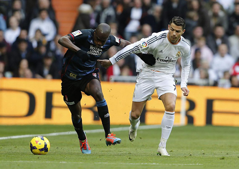 Cristiano Ronaldo fighting for the ball with a Granada defender, in the Spanish League 2013-2014