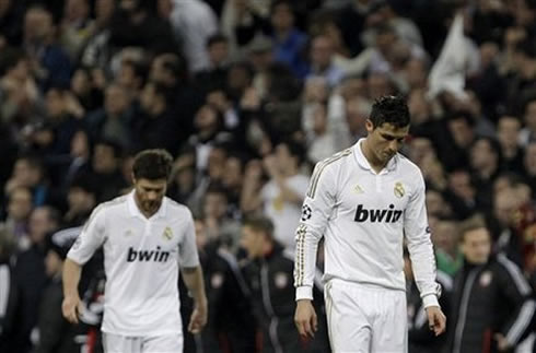 Cristiano Ronaldo and Xabi Alonso looking down and stepping away from the pitch as Real Madrid loses against Bayern Munich