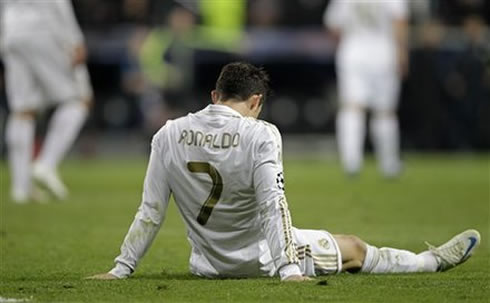 Cristiano Ronaldo sits on the pitch and stretches his legs, after Real Madrid loses against Bayern Munich in the penalty shootout
