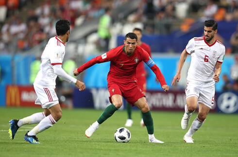 Cristiano Ronaldo between two Iran defenders in the 2018 FIFA World Cup