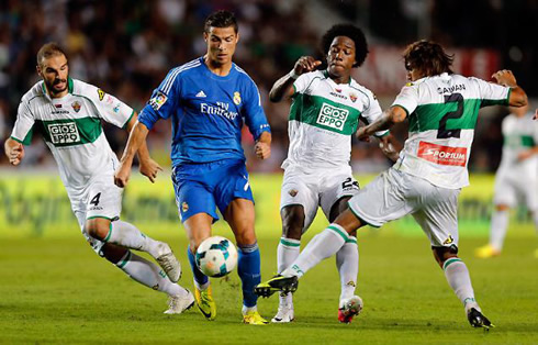 Cristiano Ronaldo in the middle of three defenders, in Elche vs Real Madrid for La Liga 2013-2014