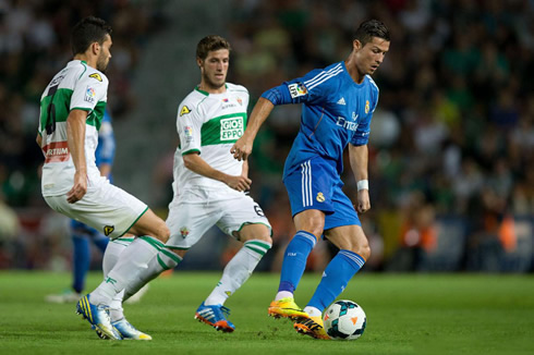 Cristiano Ronaldo handling the ball and protecting it from his opponents, in Elche vs Real Madrid