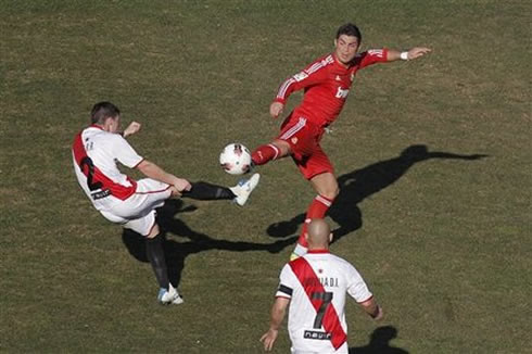 Cristiano Ronaldo stretching to reach the ball first than the defender